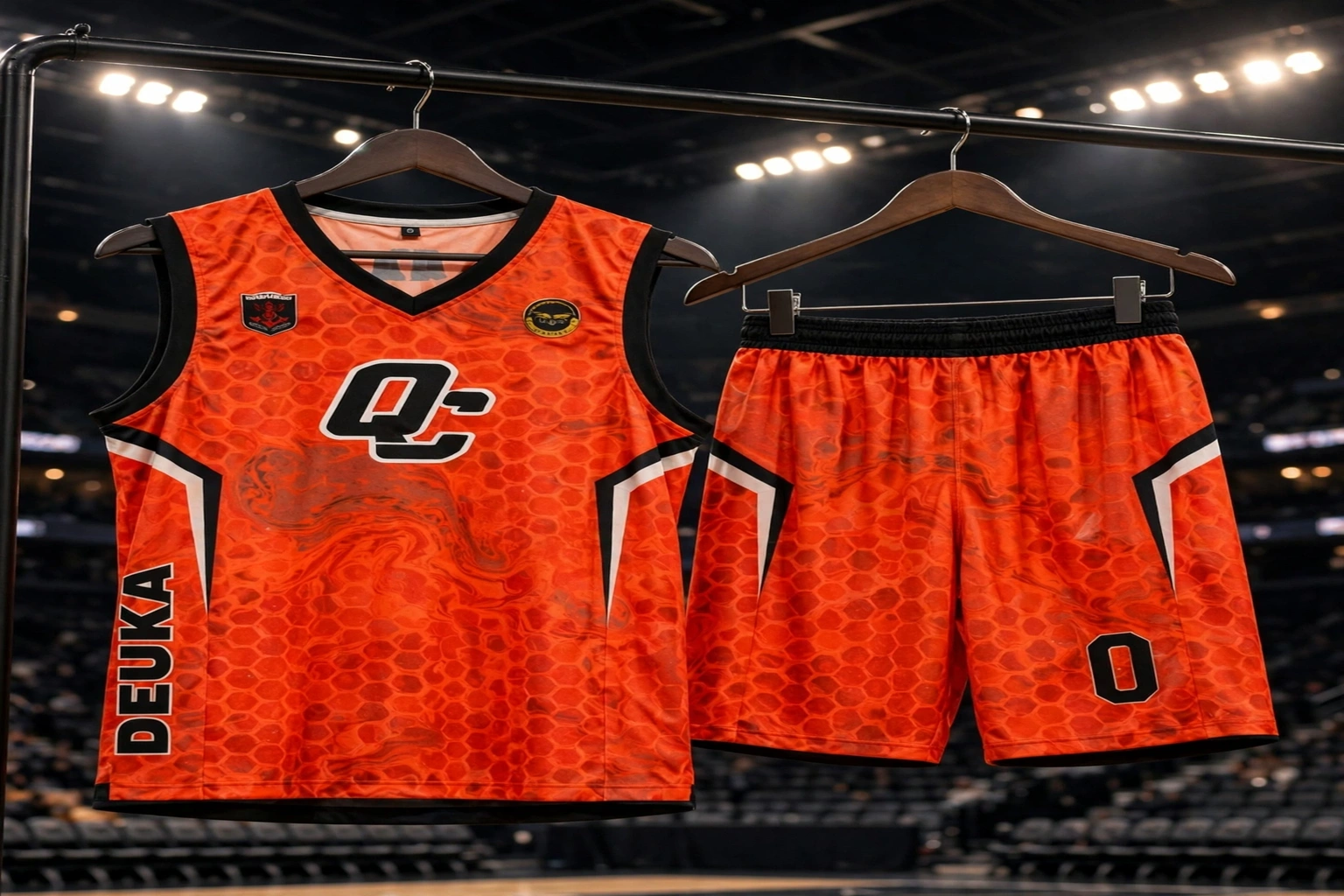Orange marble DEUKA basketball jersey and shorts set hanging courtside under bright arena lights showing flawless color consistency across uniform