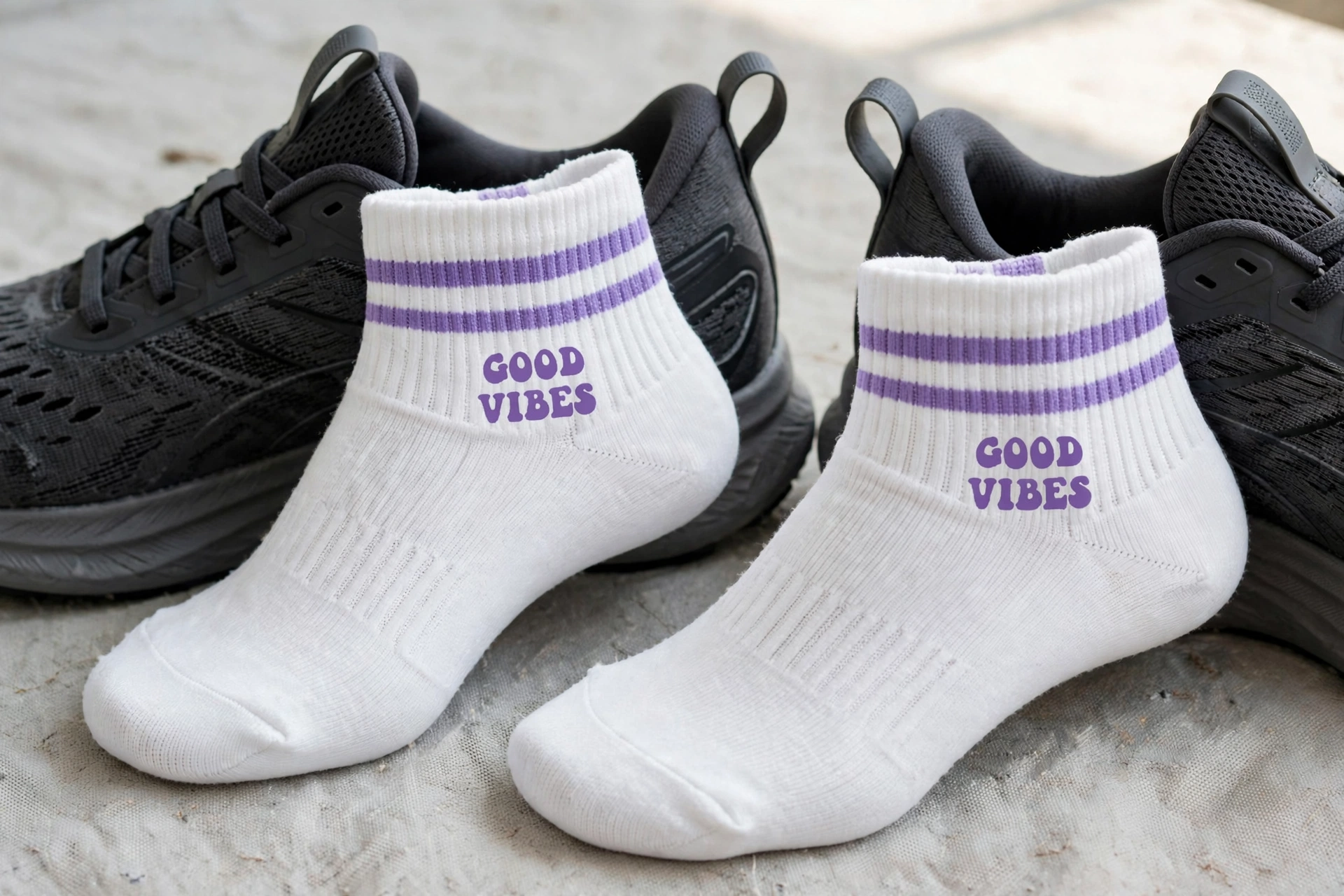White GOOD VIBES crew socks with purple double stripes styled as low-profile ankle socks sitting at collar of black running shoes with heel tabs - low-profile training ankle socks minimalist silhouette