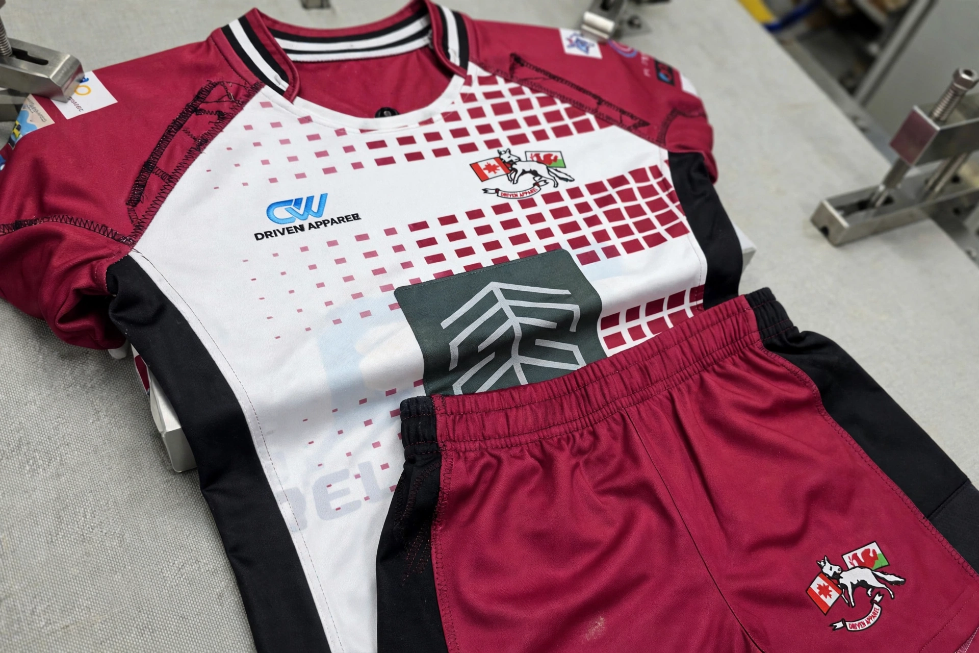 Balanced durability test of maroon white rugby jersey and shorts showing heavy-duty fabric and reinforced stitching in contact zones